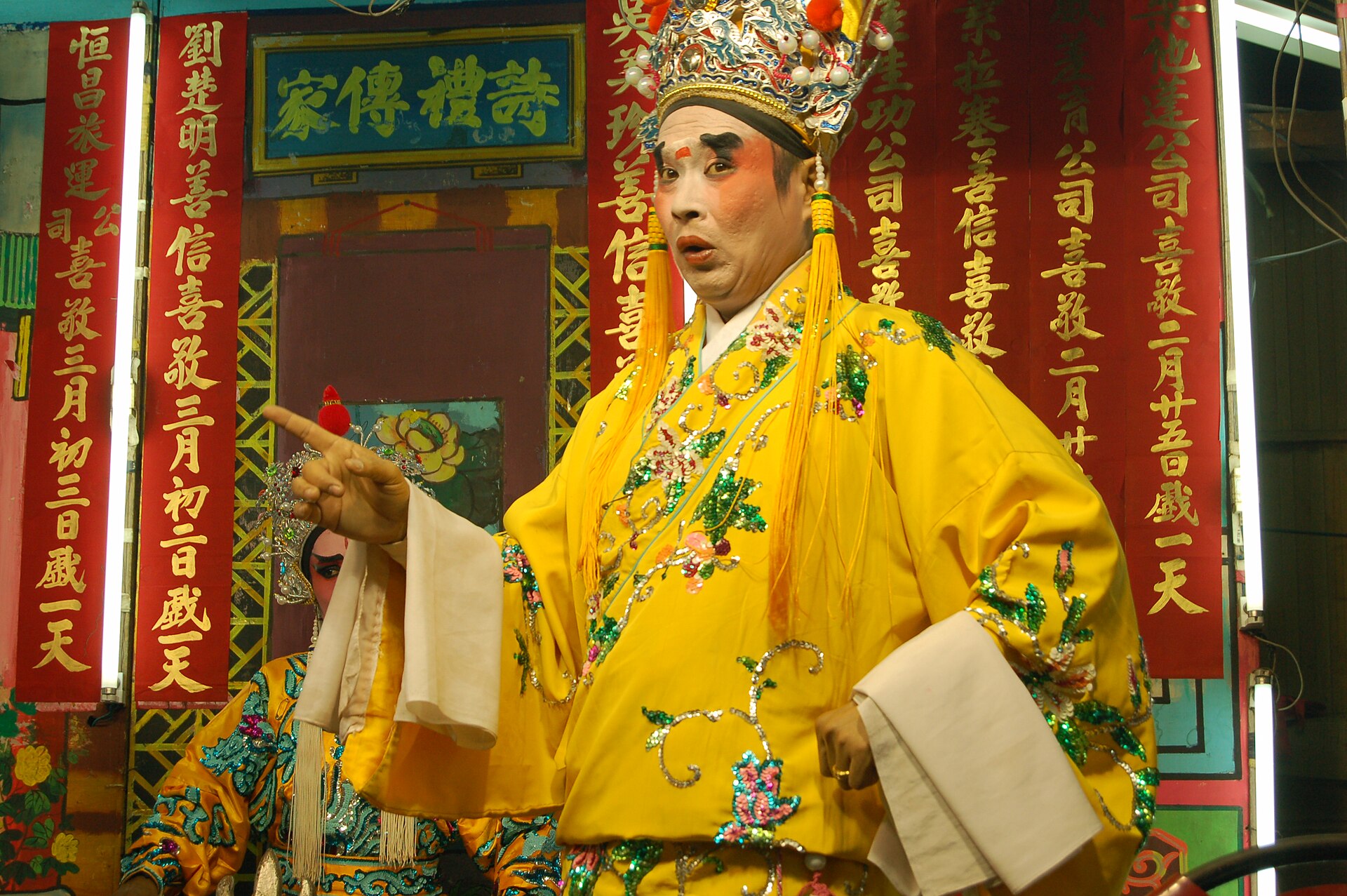 A Teochew opera performer mid-scene in Bangkok, expressive and in full costume